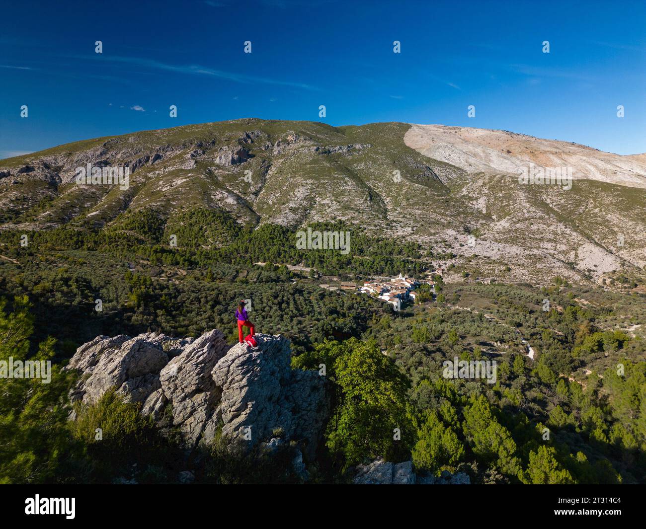 Female hiker looks out above a valley of Famorca village, Costa Blanca, Spain - stock photo Stock Photo