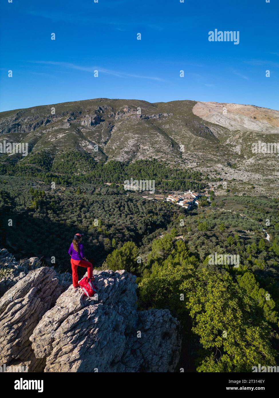 Female hiker looks out above a valley of Famorca village, Costa Blanca, Spain - stock photo Stock Photo
