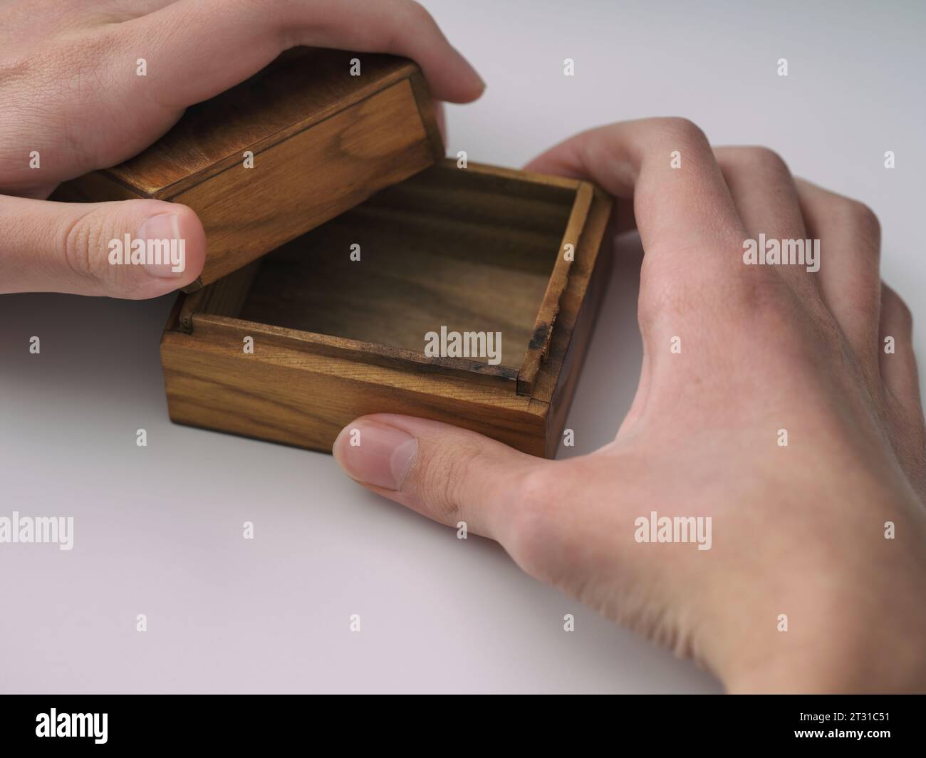 A man opening an empty small wooden box with his hands. Close-up. Stock Photo