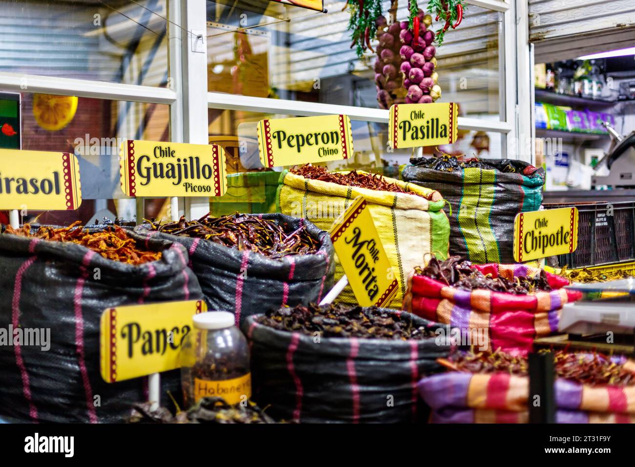 Bags of chili peppers with markers written in Spanish in a market in