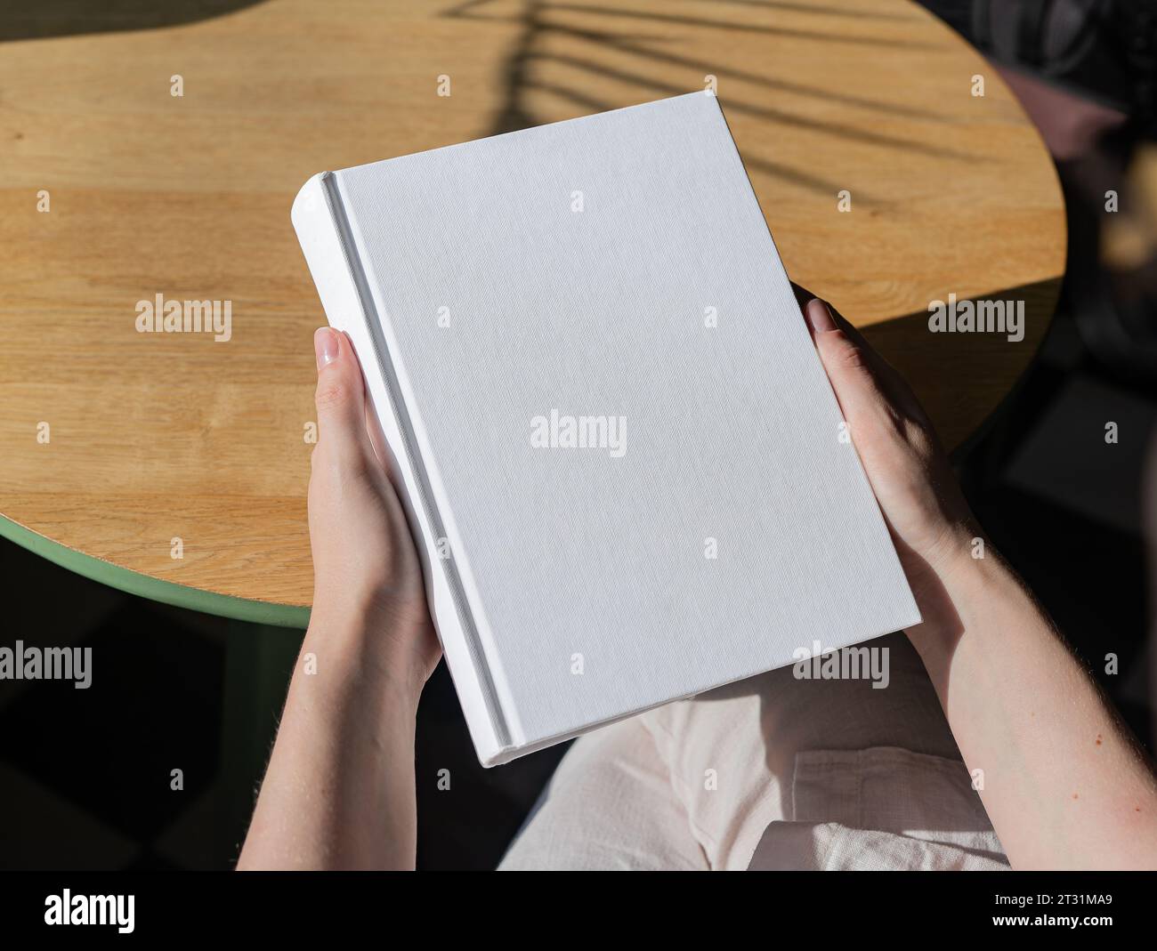 Book cover mockup, hand holding blank clean hardcover mock up on wood ...