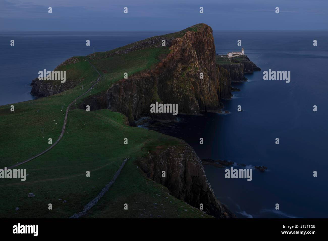 Neist Point is a dramatic headland on the Isle of Skye, with towering sea cliffs, dramatic rock formations, and an iconic lighthouse. Stock Photo