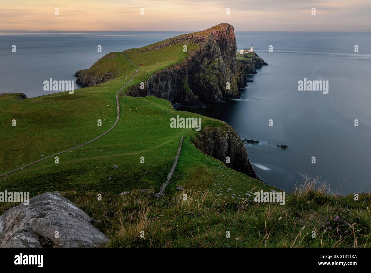 Neist Point is a dramatic headland on the Isle of Skye, with towering sea cliffs, dramatic rock formations, and an iconic lighthouse. Stock Photo