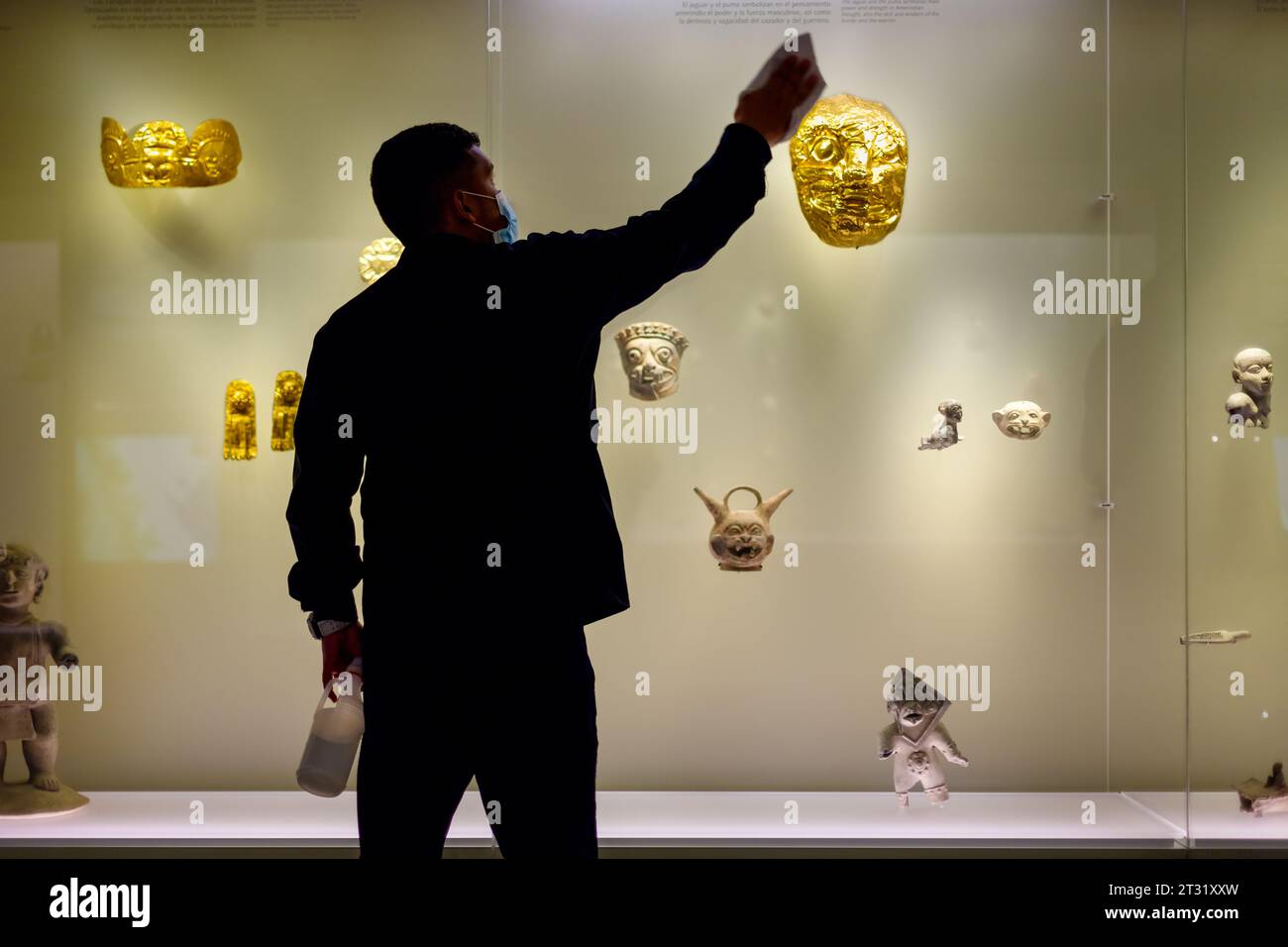 Bogota, Colombia - January 3, 2023: Employee of the Gold Museum cleans the glass of the exhibition window Stock Photo