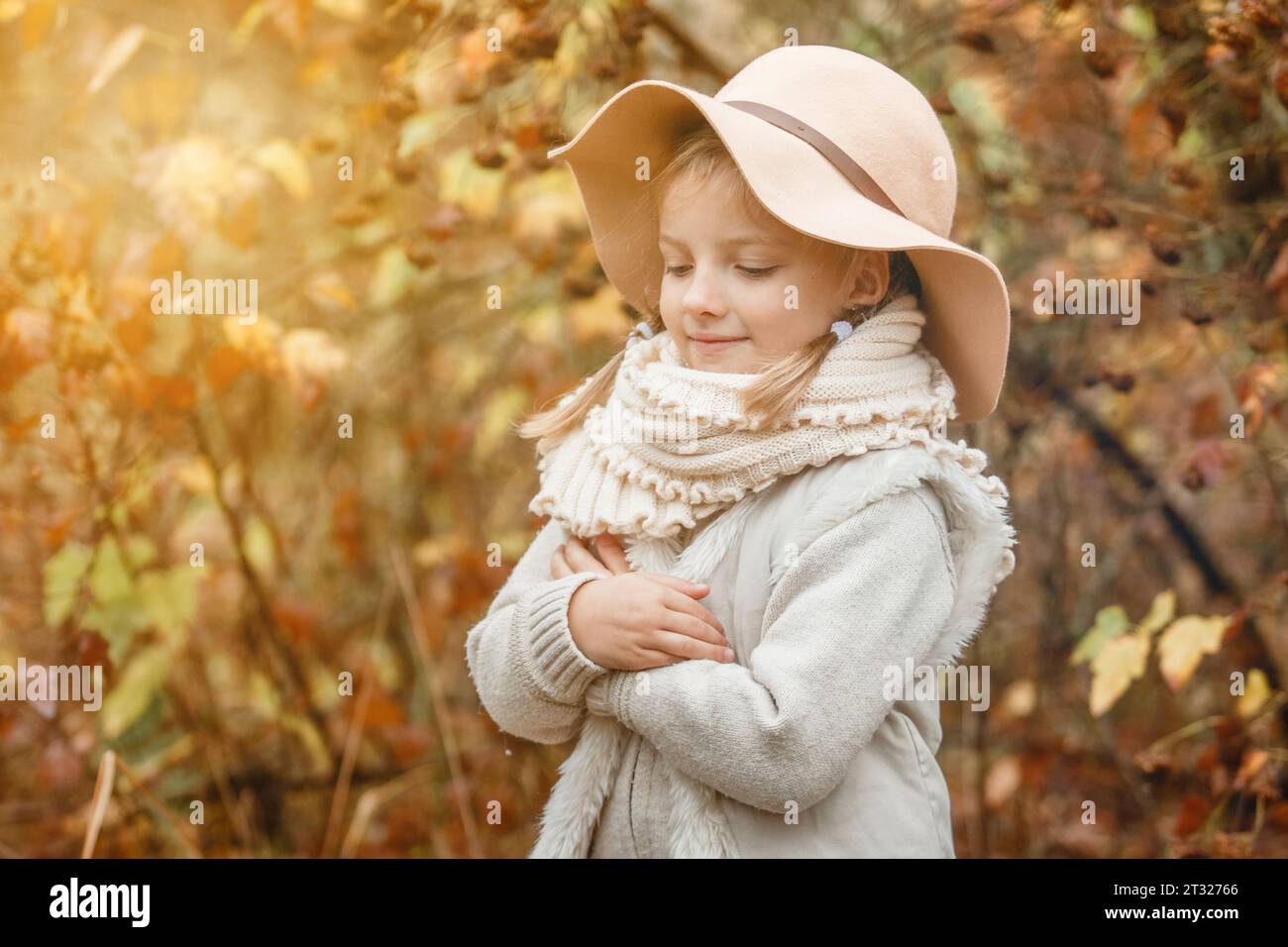 Portrait of a smiling young girl in a hat in an autumn park. Horizontal ...
