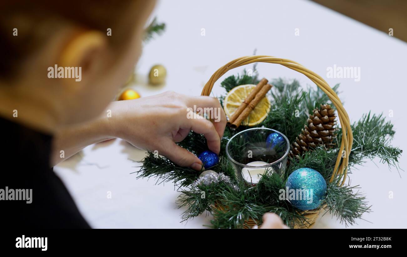 Close up of small basket with pine tree branches and toy balls. Art. Christmas decorations, concept of winter holidays. Stock Photo