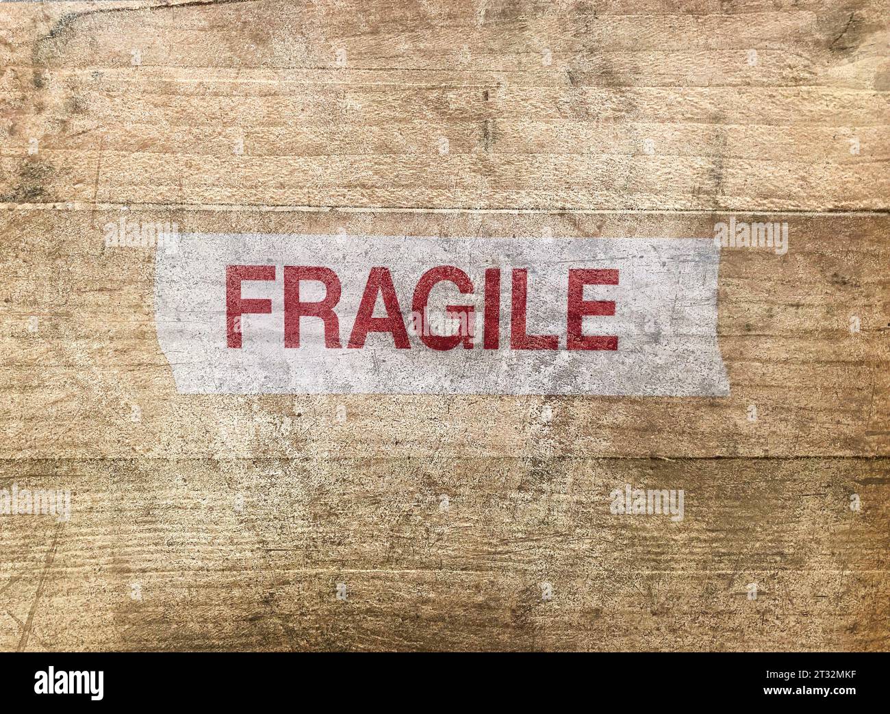 Close up photo of dirty wooden cargo box written "fragile" on it as a