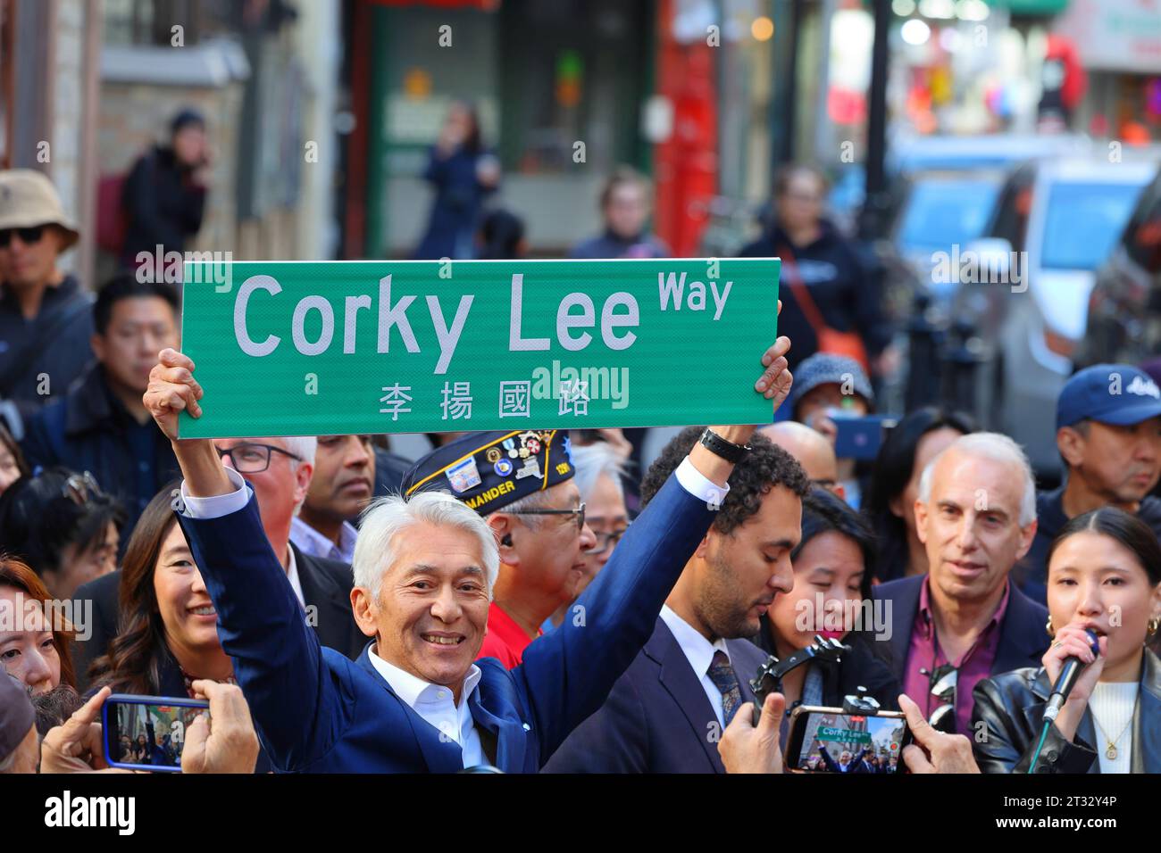 22 October 2023, New York. People celebrate Corky Lee Way 李揚國路 co-naming of Mosco St in Manhattan Chinatown. John Lee, a sibling of Corky Lee, holds a Corky Lee Way street sign. Corky Lee was a photojournalist, photographer and civil rights activist who documented Asian American history; he is sometimes referred to as the 'unofficial Asian American photographer laureate'. Mr. Lee died in 2021 from complications due to Covid-19. Stock Photo