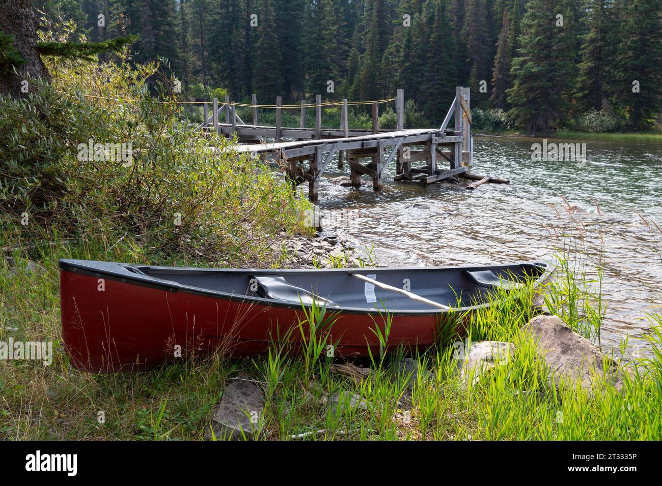 A canoe is beached along Swiftcurrent Lake in the Many Glacier area of Glacier National Park, Montana. Stock Photo