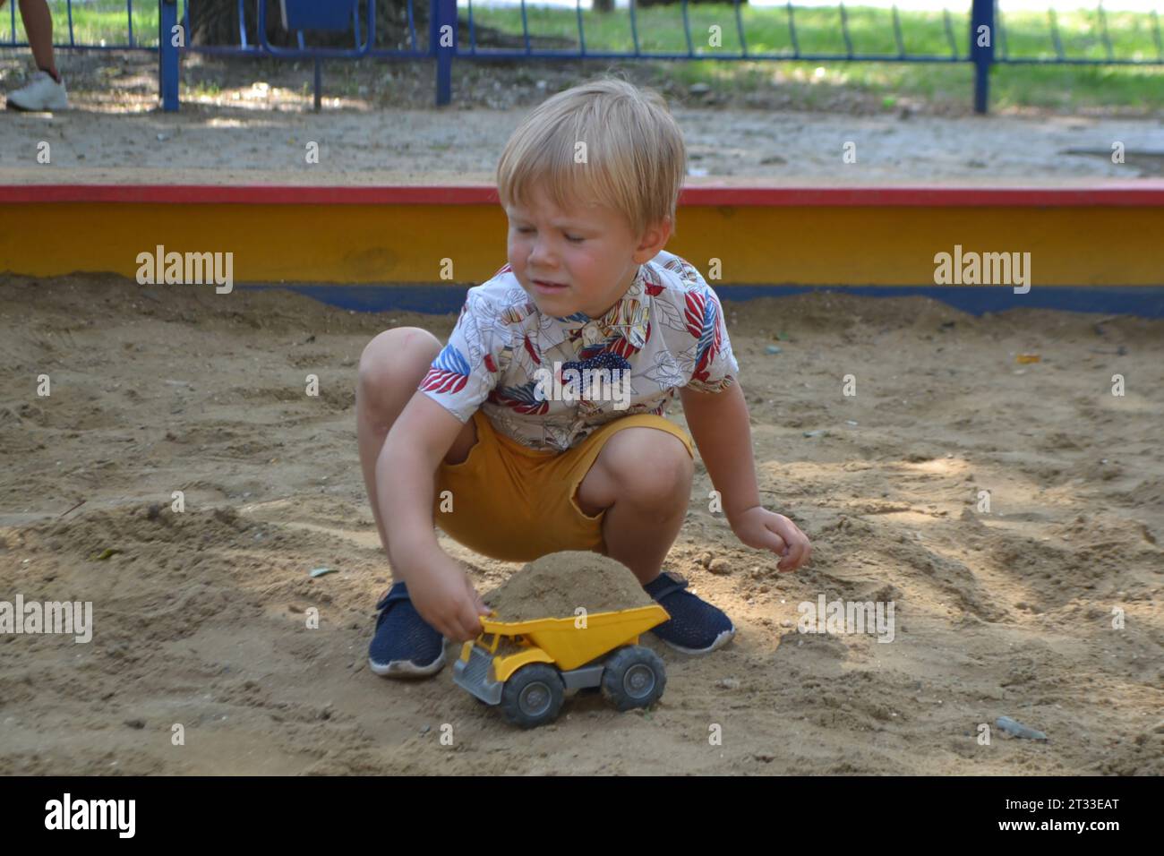 Cute toddler boy playing in sand on outdoor playground. Beautiful baby having fun on sunny warm summer day. High quality photo Stock Photo