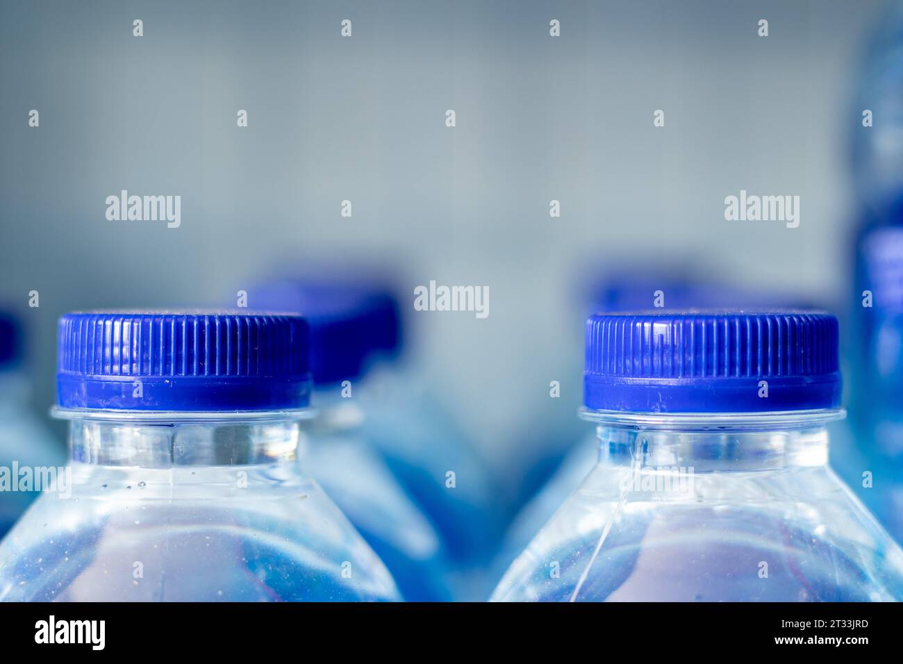 Mineral water bottles in a row with blue caps Stock Photo Alamy