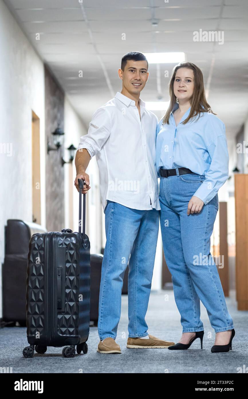 Young couple in hotel hallway get ready to check-in Stock Photo