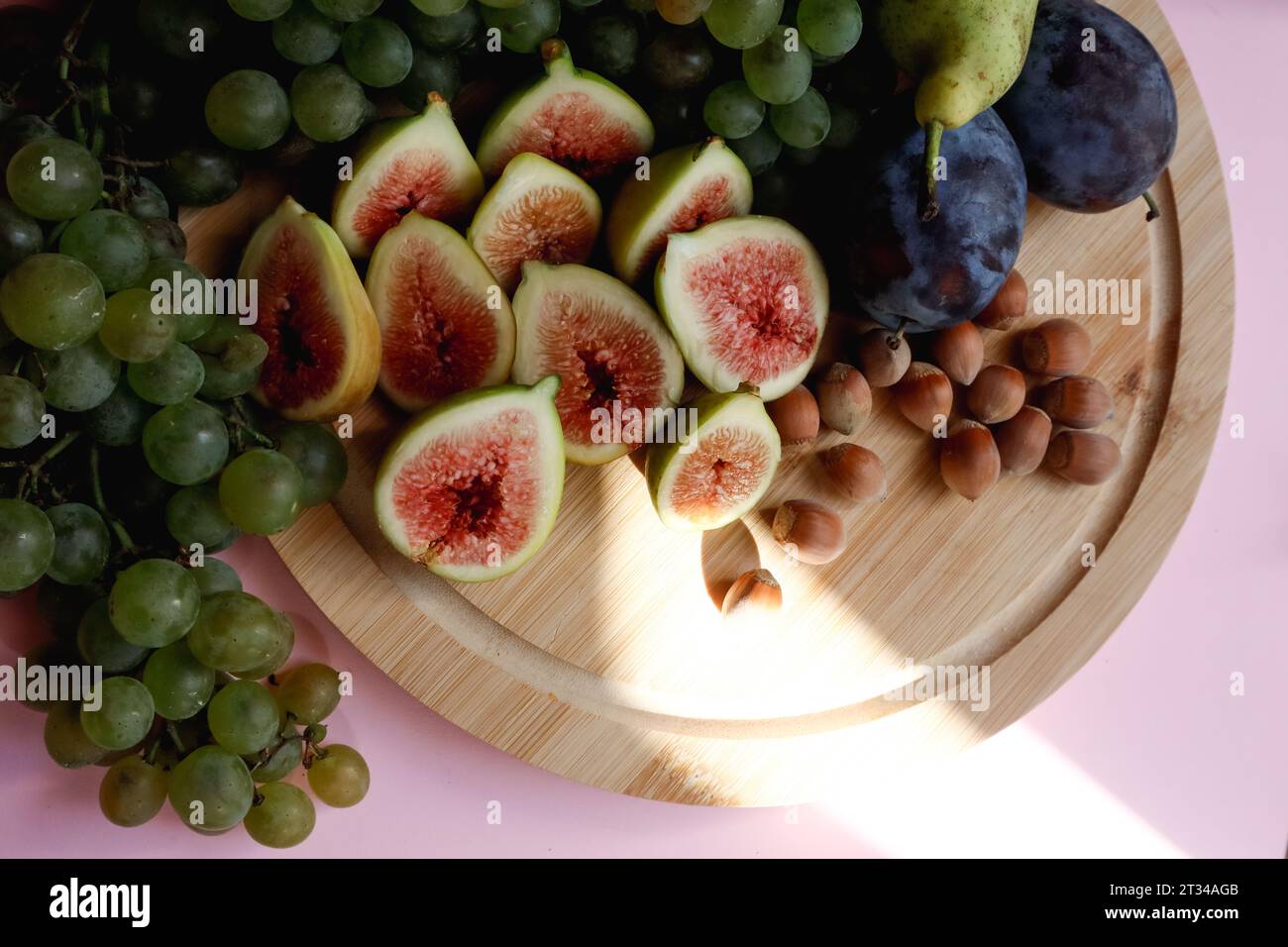 Autumn harvest of fruits on the board - figs, grapes, nuts, plums Stock Photo