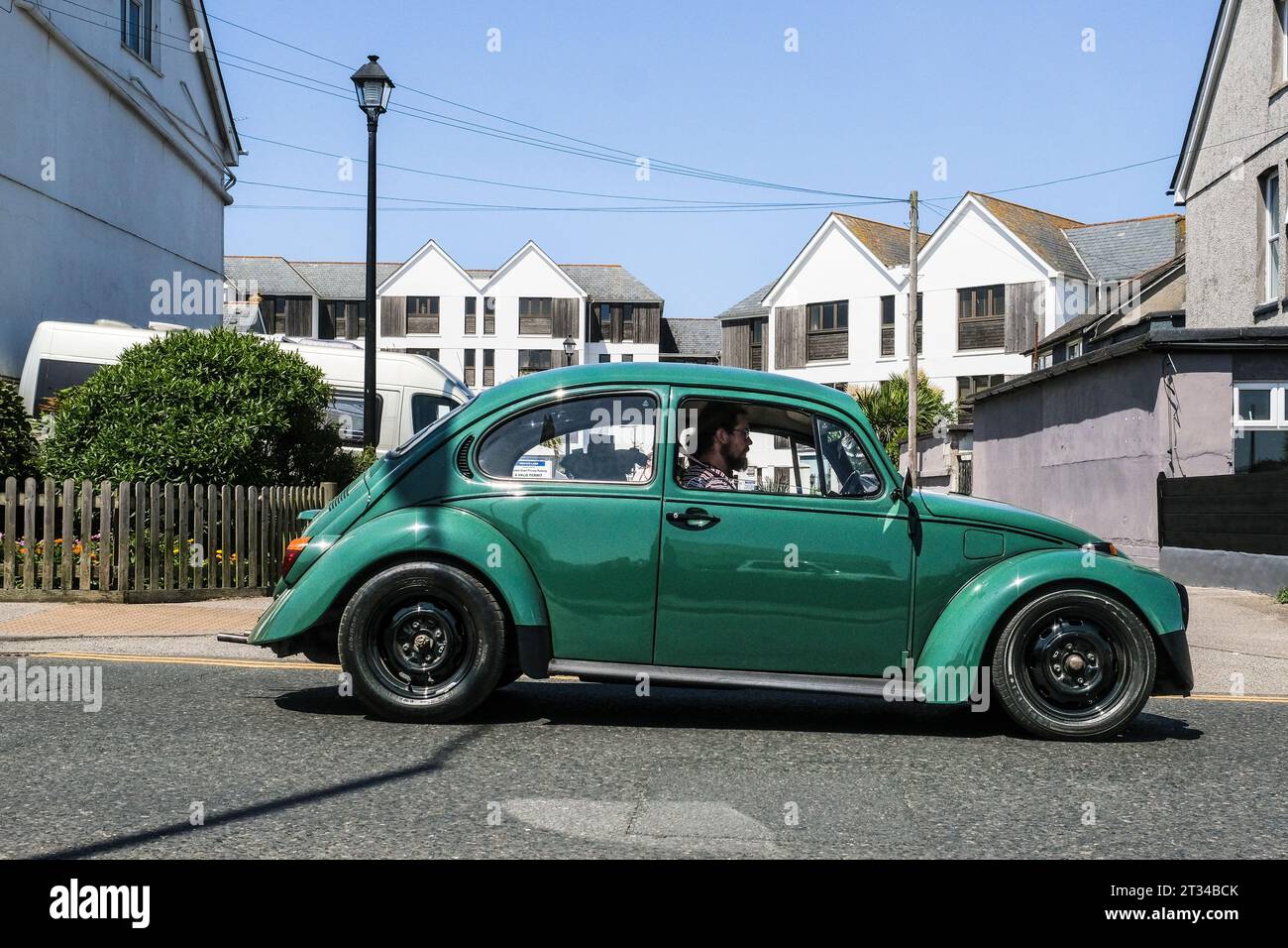 A restored vintage Volkswagen car being driven on a street in Newquay Town Centre in Cornwall in