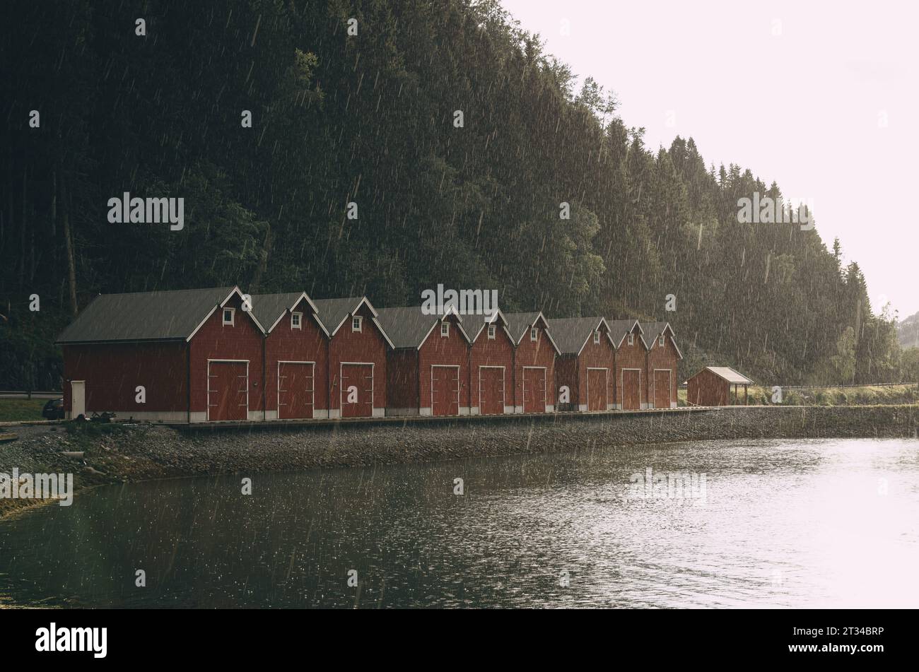 red wooden houses on the shore of a fjord in Norway in rainy weather Stock Photo
