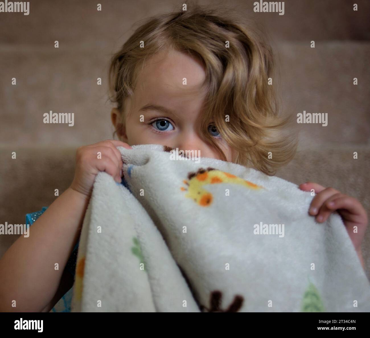 Beautiful sleepy little girl smelling blanket before nap Stock Photo