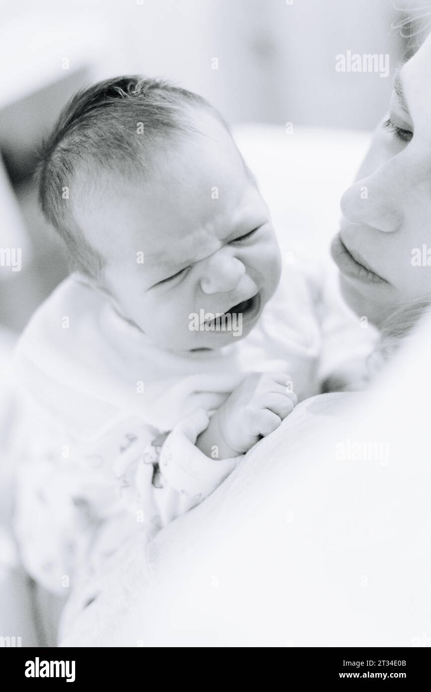 One week old newborn baby crying on his mothers shoulder Stock Photo ...