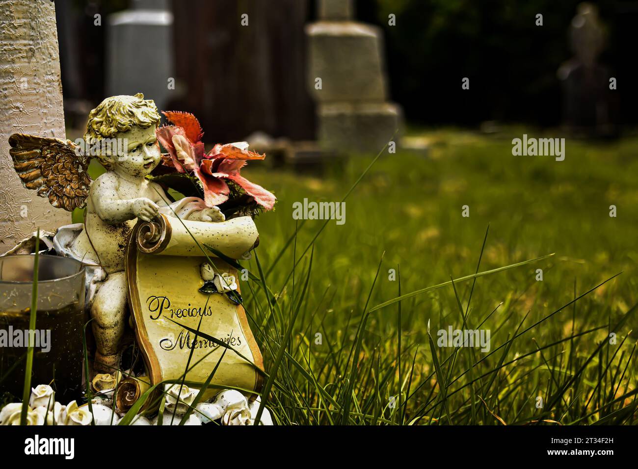 A delicate angel statue with the words 'Precious Memories' stands quietly in The Glendalough Graveyard, Ireland. Stock Photo