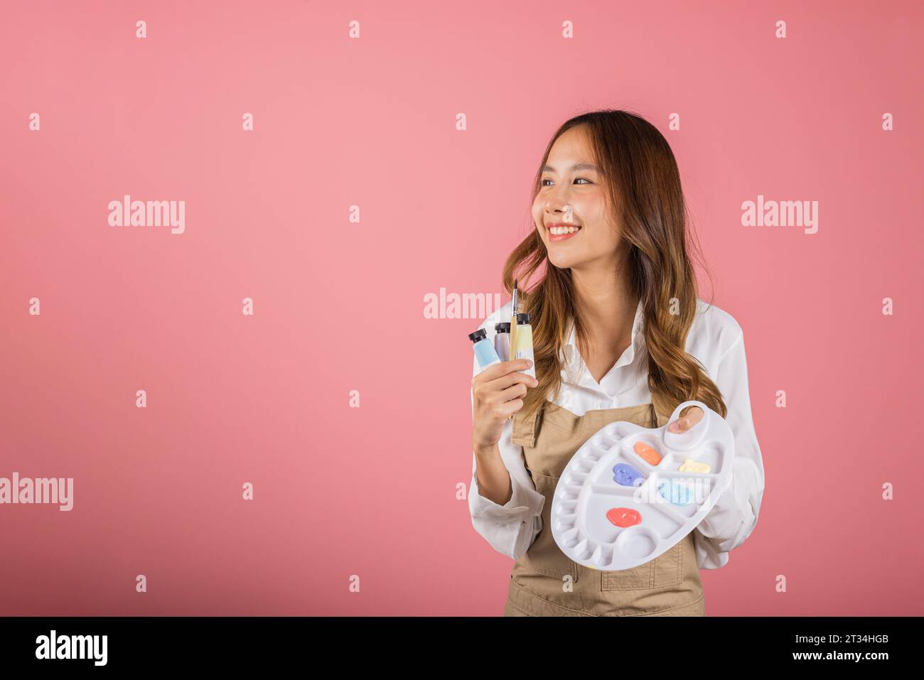 Happy female painting using paintbrush and palette with colors Stock ...
