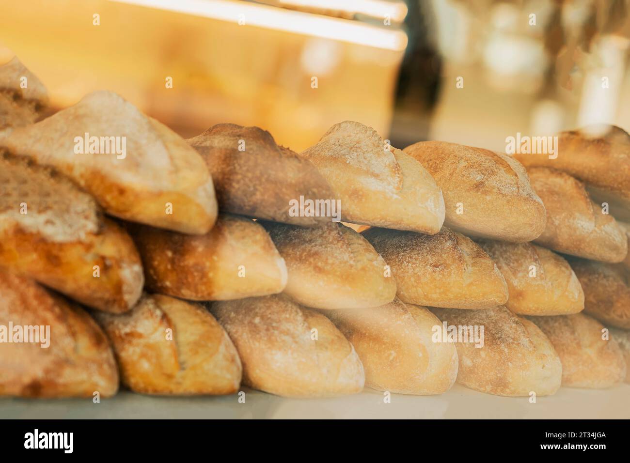 Fresh organic bread on shelves stand of shop, bakery. Freshly baked bread loaves at window of
