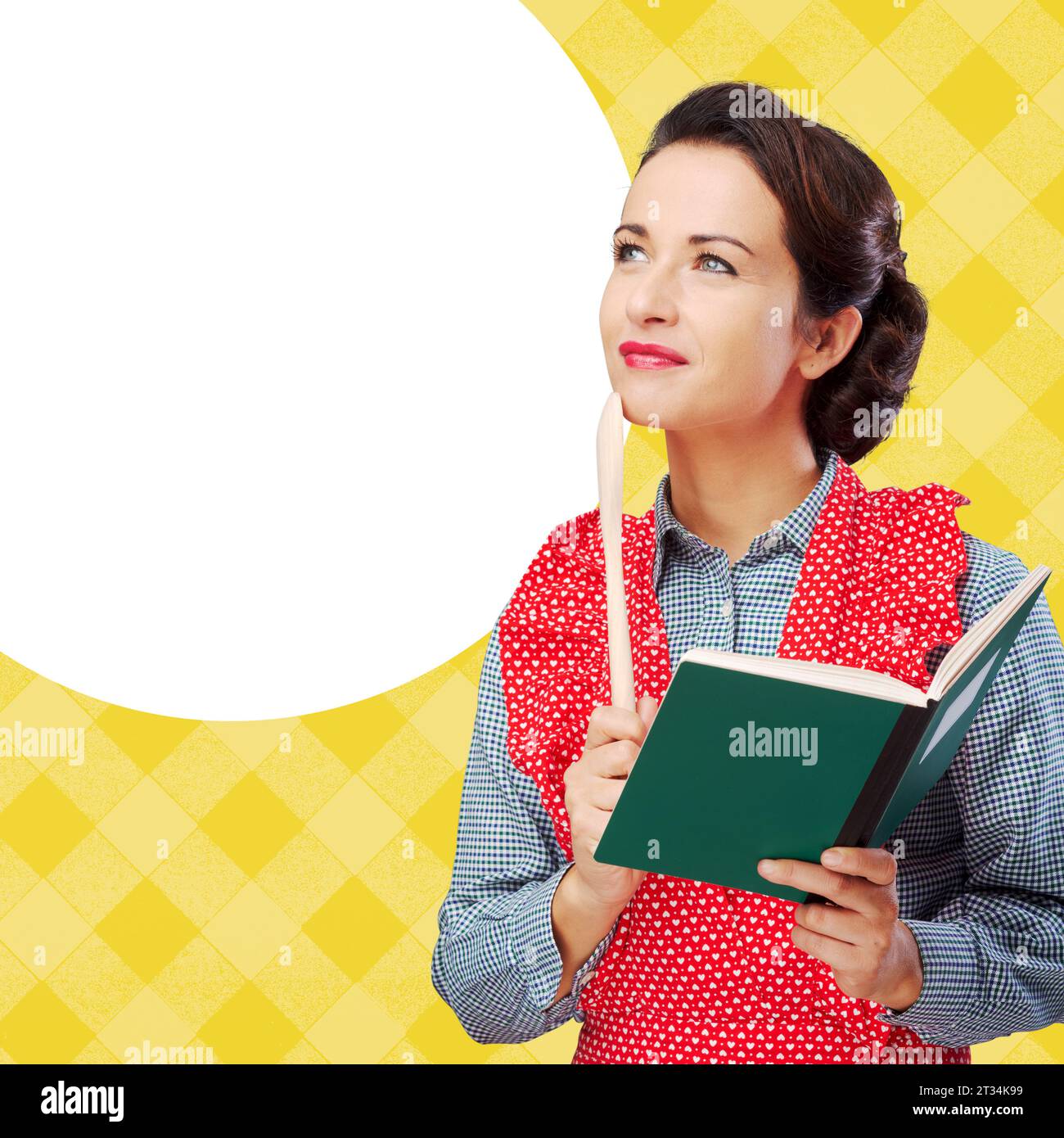 Smiling vintage woman holding an open cookbook and a wooden spoon Stock Photo