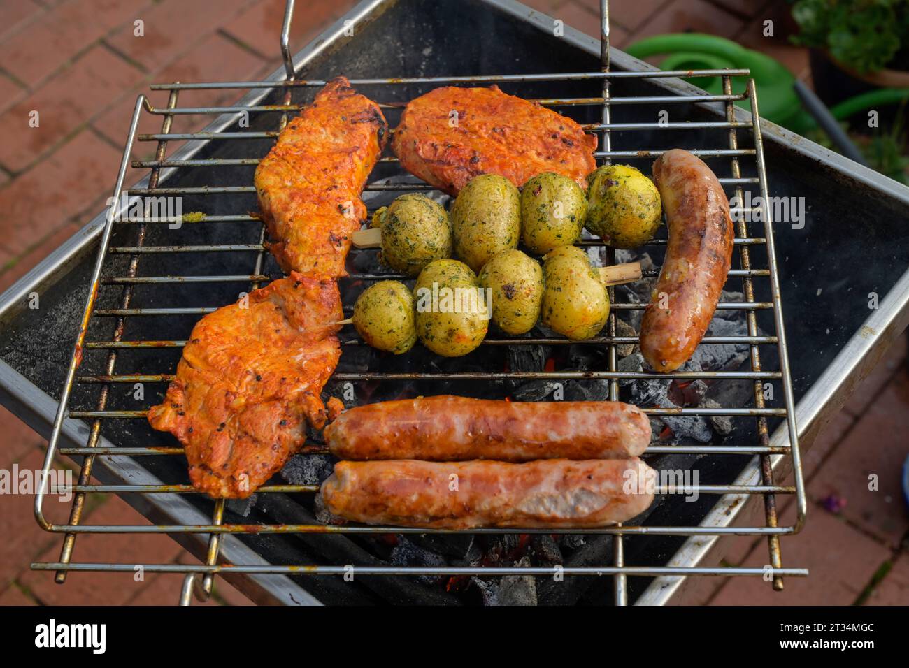 Schnitzel, Bratwürstchen, Kartoffeln, Holzkohlengrill, Deutschland Stock Photo