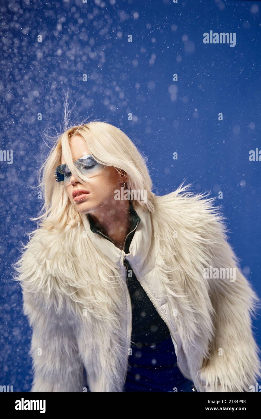 blonde young woman in faux fur jacket and sunglasses posing under ...