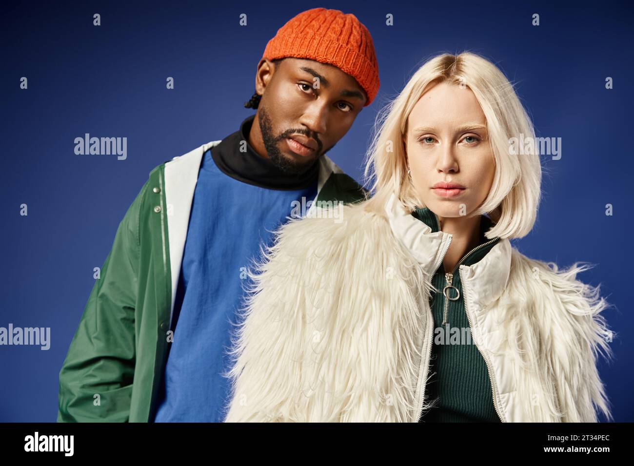 interracial couple in modern winter attire, young woman in faux fur jacket and african american man Stock Photo