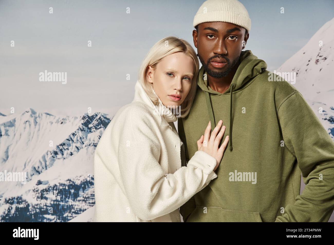 attractive woman posing with hand on her boyfriend chest with mountain backdrop, fashionable couple Stock Photo