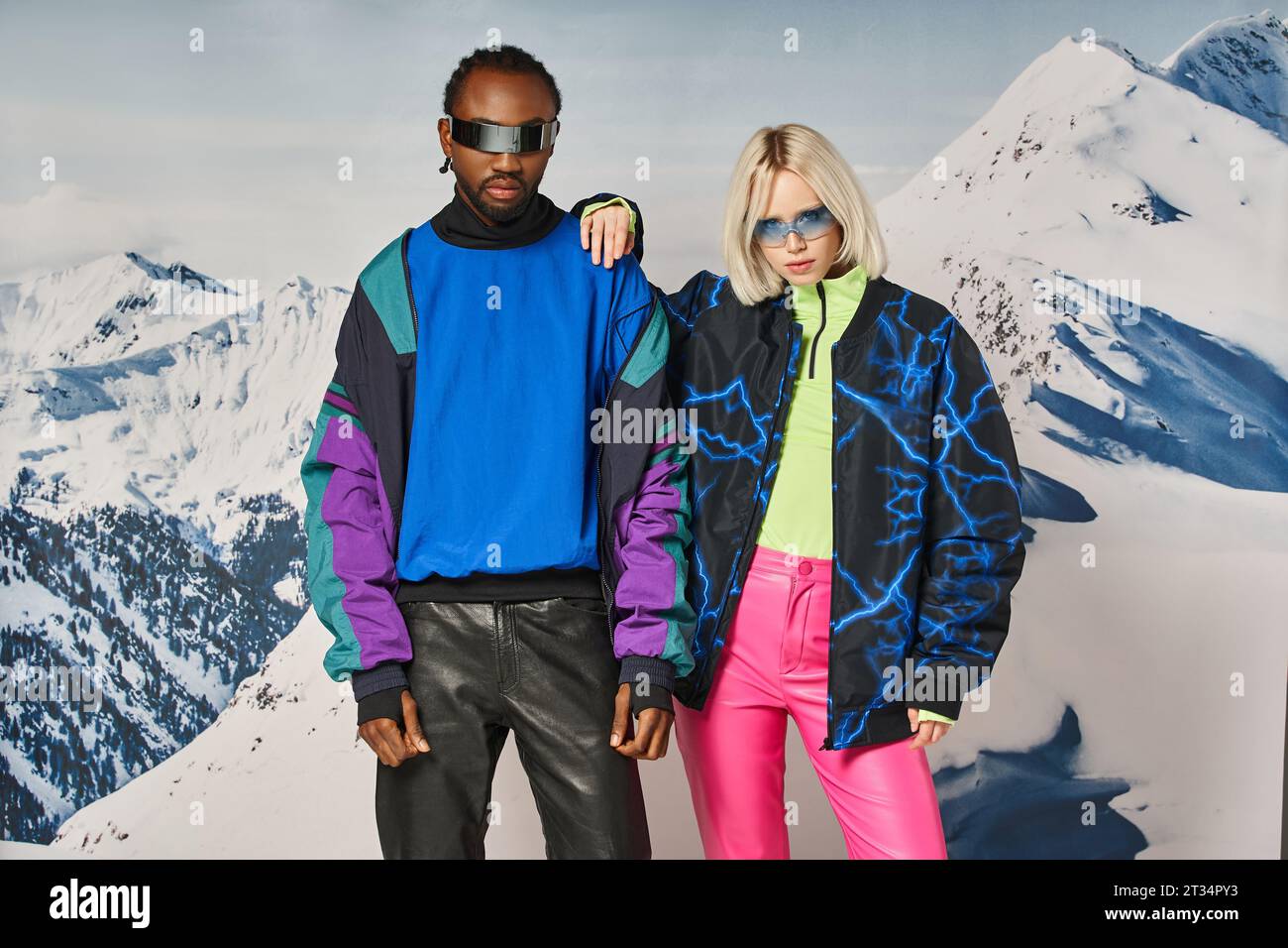 multiethnic couple posing in winter attire with mountain on backdrop, african american man and woman Stock Photo