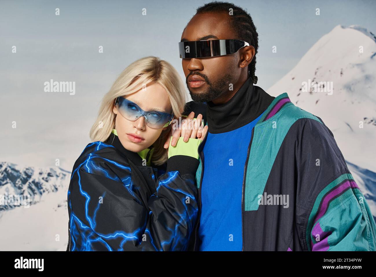 loving stylish interracial couple in warm vibrant attire hugging and looking away, winter concept Stock Photo