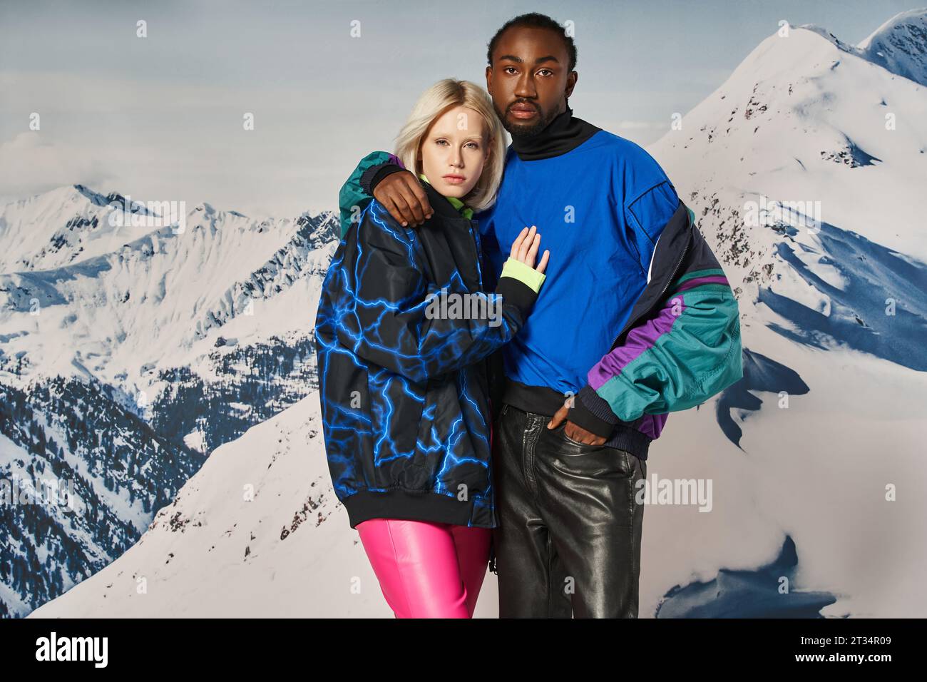 attractive interracial couple in stylish outfits hugging and looking at camera, winter concept Stock Photo