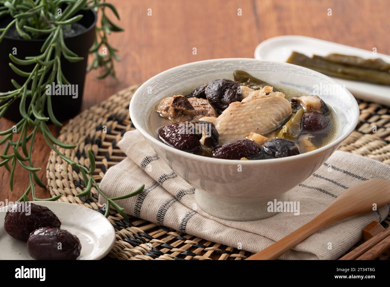 Delicious Taiwanese peeled green chili pepper chicken soup with mushroom in a bowl on wooden table background. Stock Photo