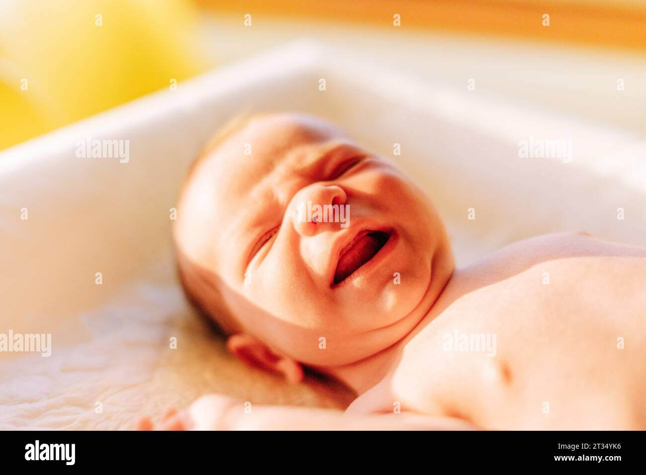 Portrait of a one week old newborn baby crying on a baby changer Stock ...