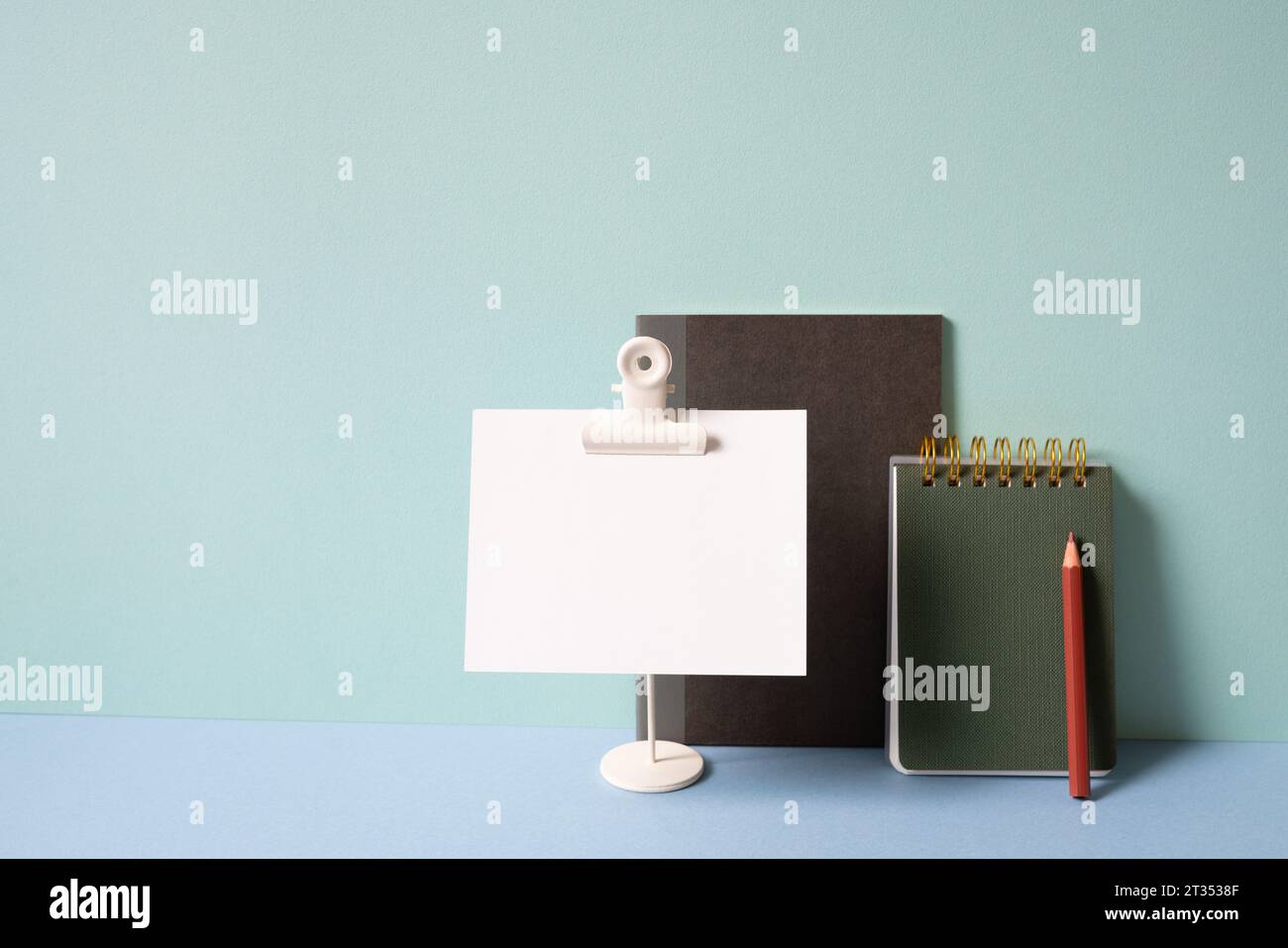 Notebook, memo pad, colored pencil on blue desk. mint green background. study and workspace Stock Photo