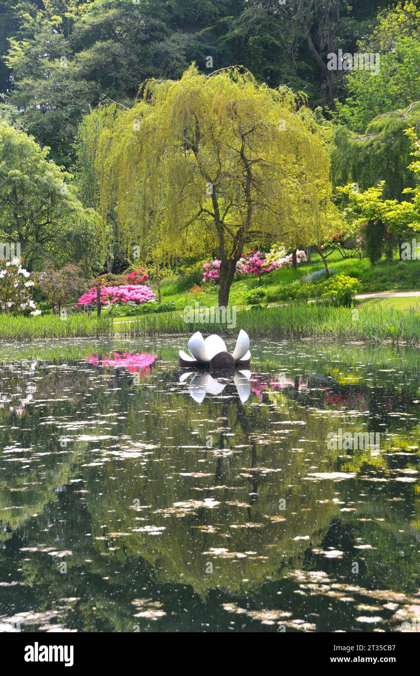 Floating Lily Sculpture & Tree Reflected in the Magnolia Lake at the Himalayan Garden & Sculpture Park near Ripon, North Yorkshire, England, UK. Stock Photo