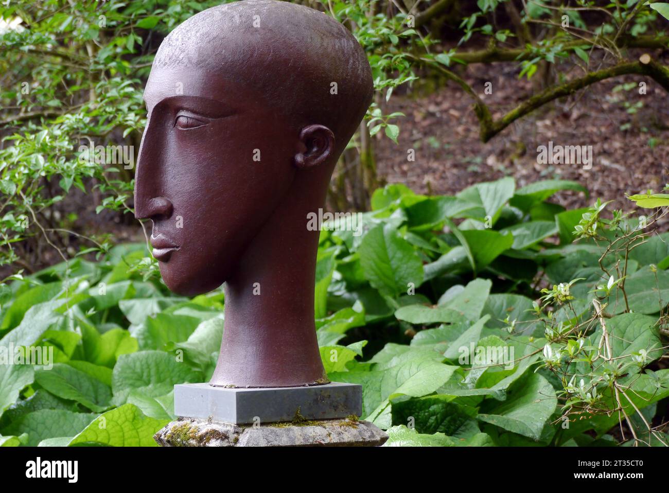 Large Brown Tribal Head by Ceramic Sculptor Patricia Volk in the Woods in the Himalayan Garden & Sculpture Park, North Yorkshire, England, UK. Stock Photo