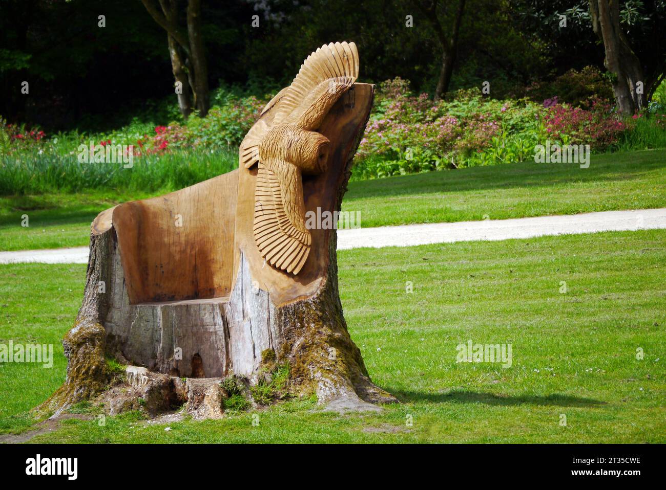 Chainsaw Carved Sculpture of a Seat with Flying Barn Owl by Karl Barker in the Himalayan Garden & Sculpture Park, North Yorkshire, England, UK. Stock Photo