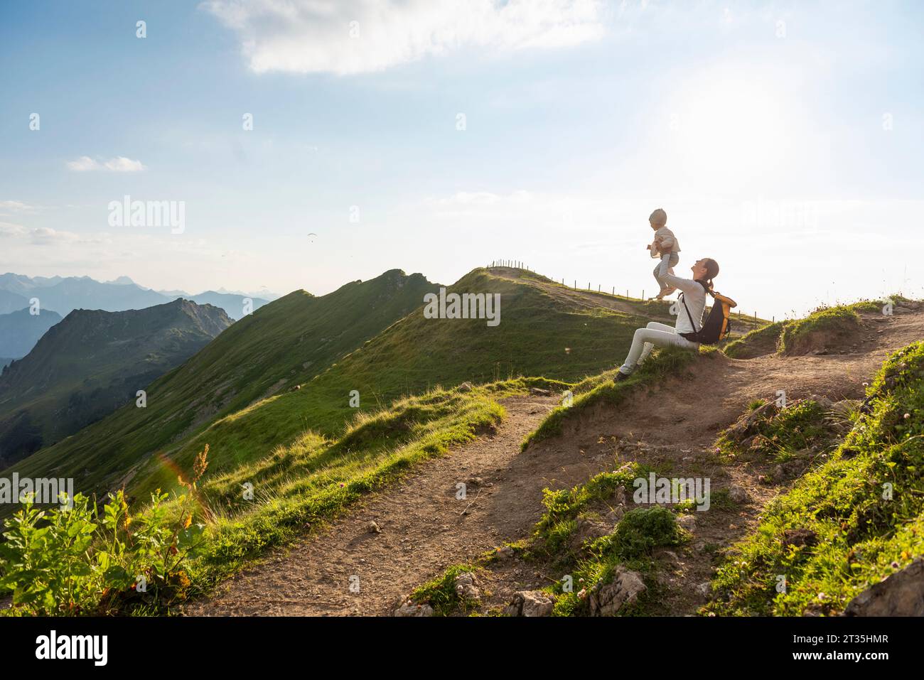 Germany, Bavaria, Oberstdorf, mother and little daughter on a hike in the mountains having a break Stock Photo