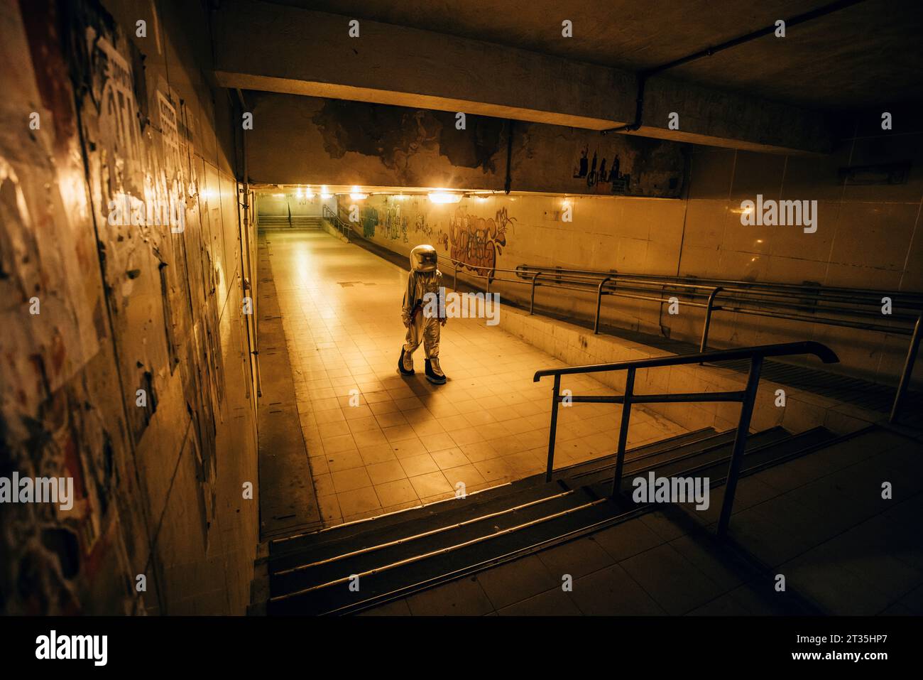 Spaceman in the city at night walking in underpass Stock Photo