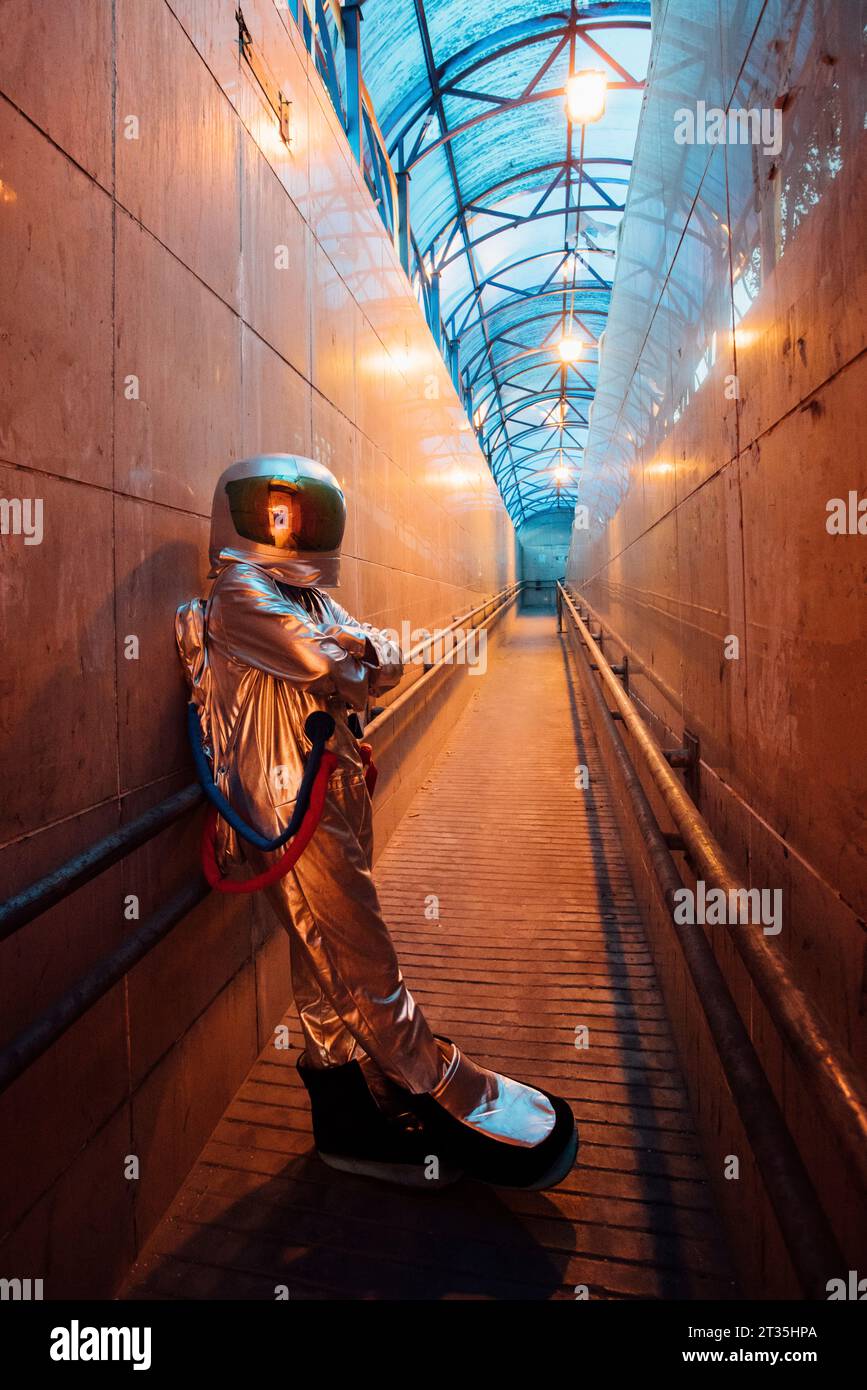 Spaceman in the city at night standing in narrow passageway Stock Photo ...