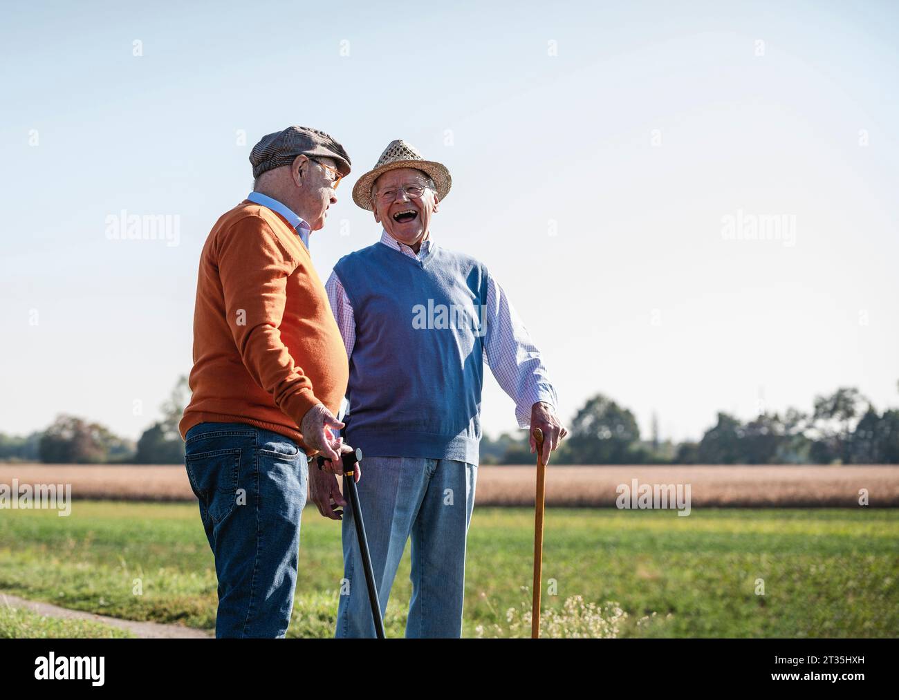 Two old friends standing in the fields, talking about old times Stock Photo