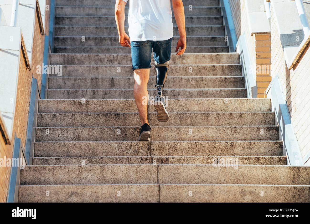 Young man with leg prosthesis walking upstairs Stock Photo Alamy