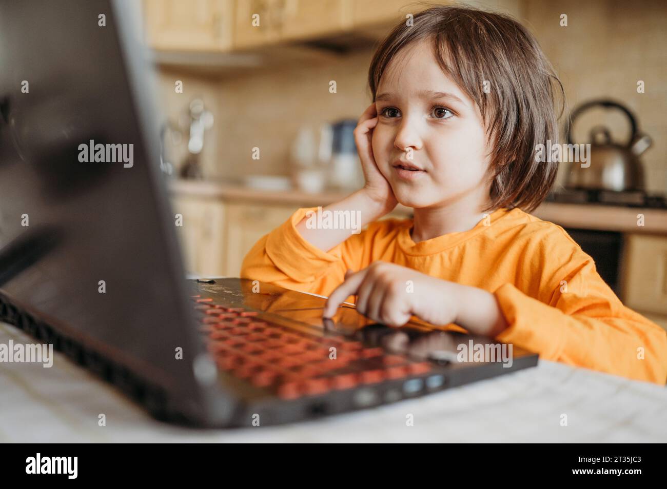 Curious boy using laptop at home Stock Photo