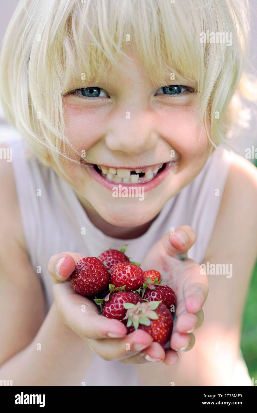 Smiling girl holding fresh strawberries Stock Photo - Alamy