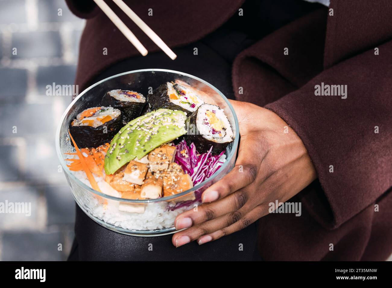 Hands of businesswoman with chopsticks and bowl of meal Stock Photo