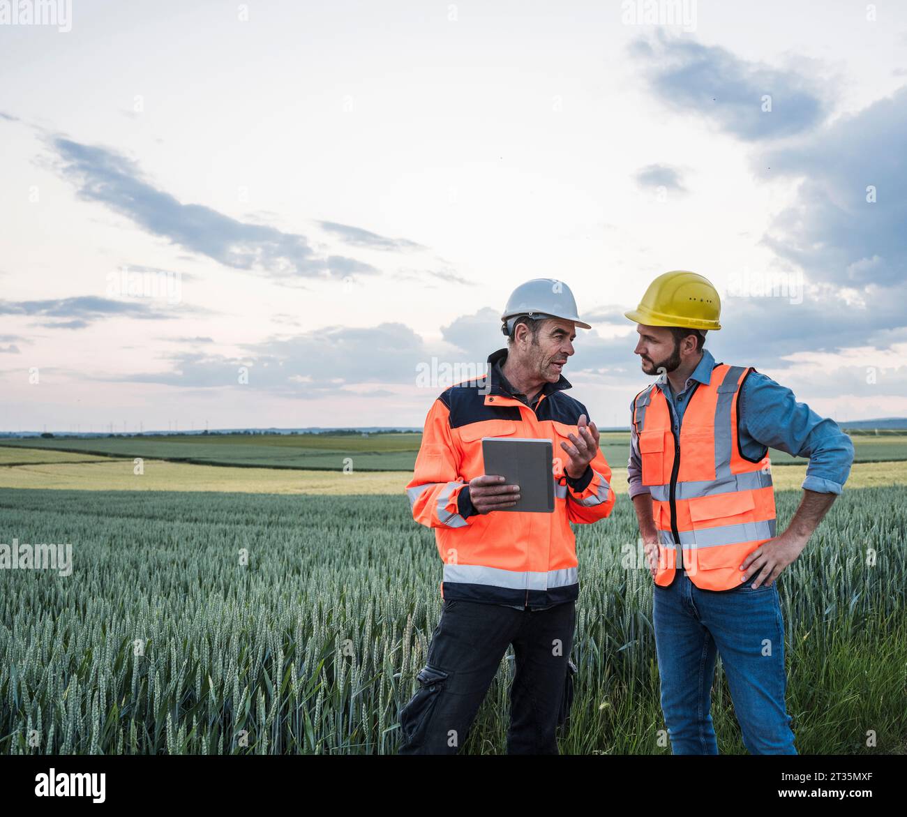 Engineers with tablet PC discussing at field Stock Photo