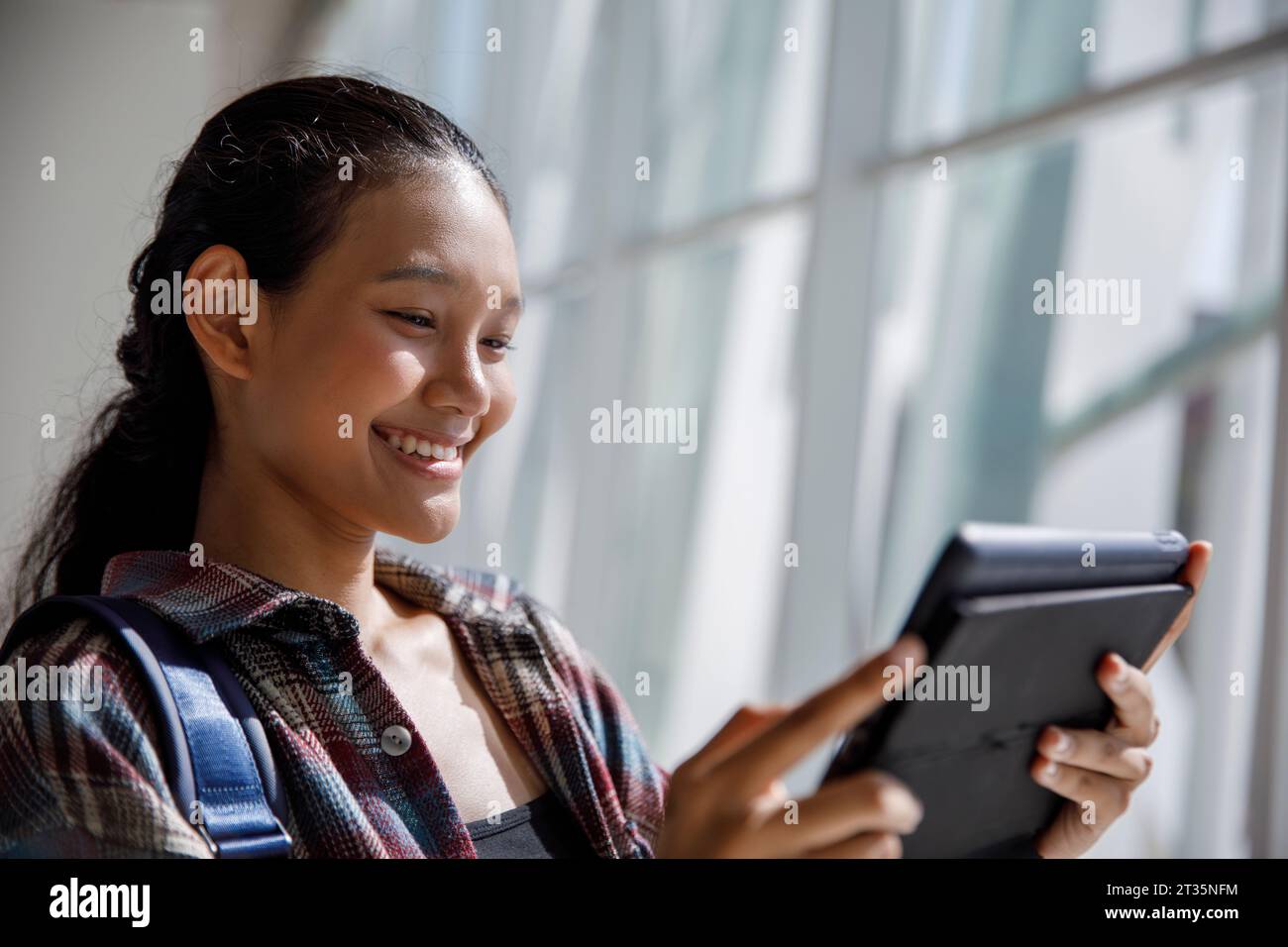 Smiling student using tablet PC in university Stock Photo