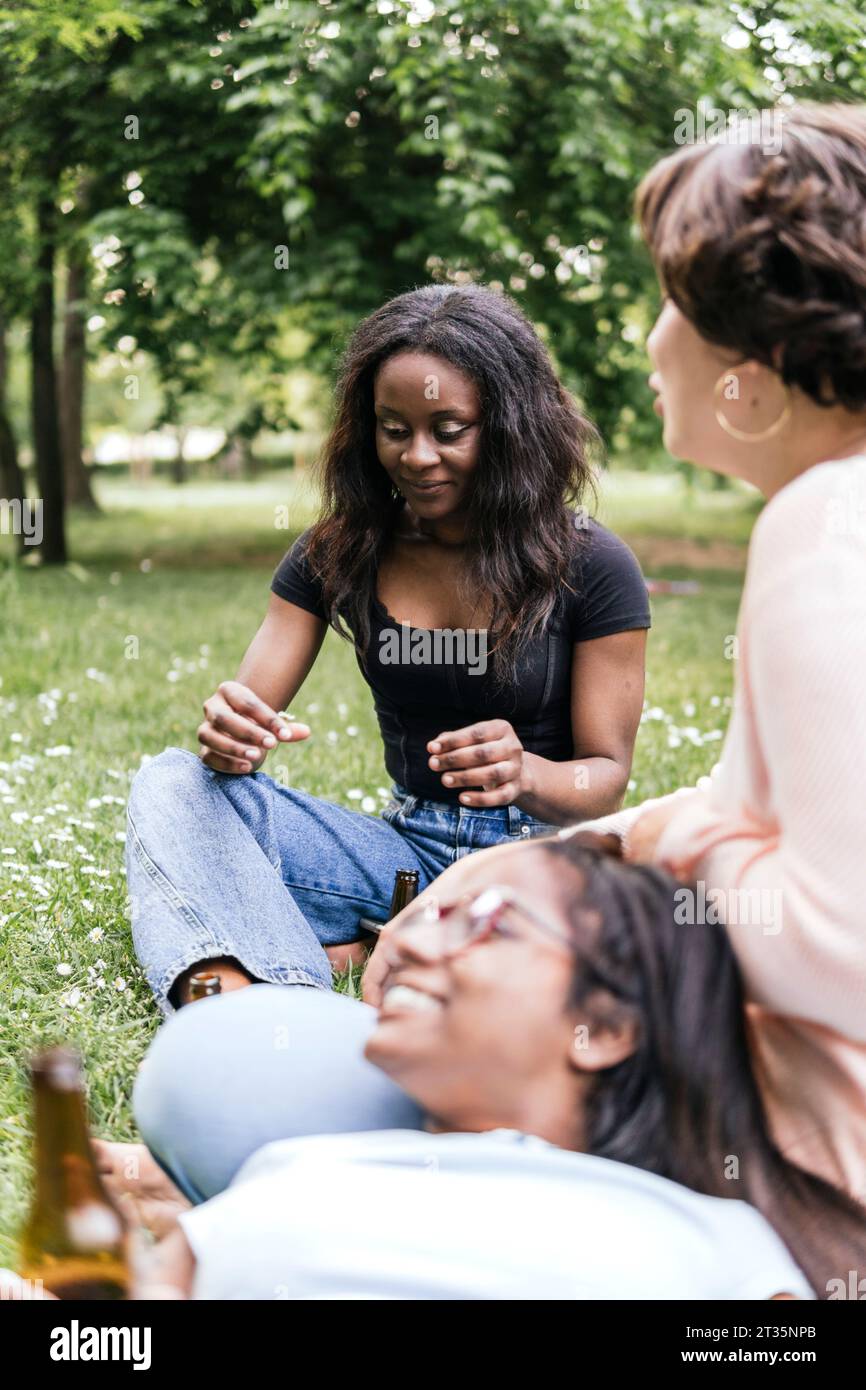 Young friends sitting on meadow hi-res stock photography and images - Alamy