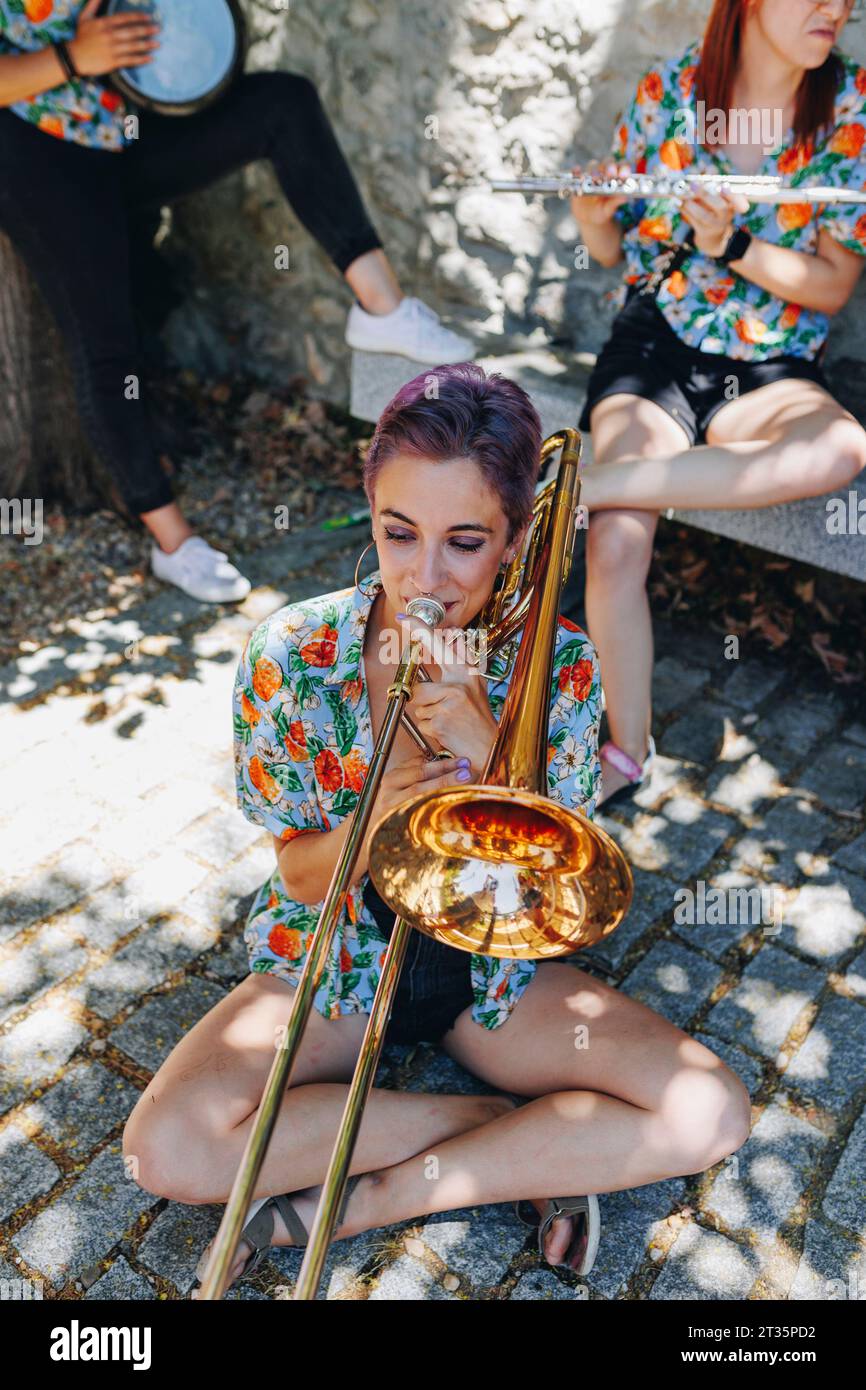 Woman playing trombone sitting crosslegged on floor Stock Photo Alamy